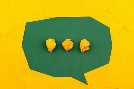 A chat bubble made of yellow note cards