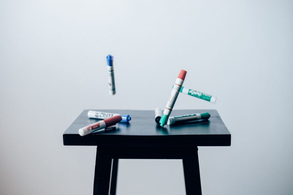 Unsplash image of whiteboard markers and a table. 