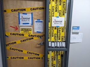 an office door covered in strips of caution tape