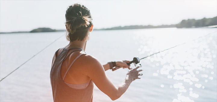 Woman casting with a fishing pole on a wisconsin lake