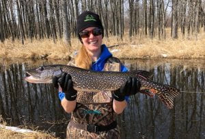 Student holding large northern pike