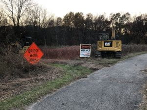 Image of an excavator and trail closed sign