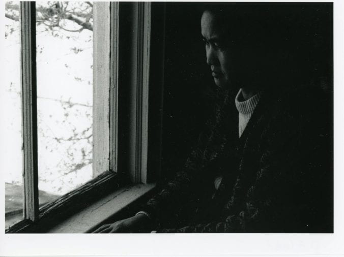 A woman stands at a window